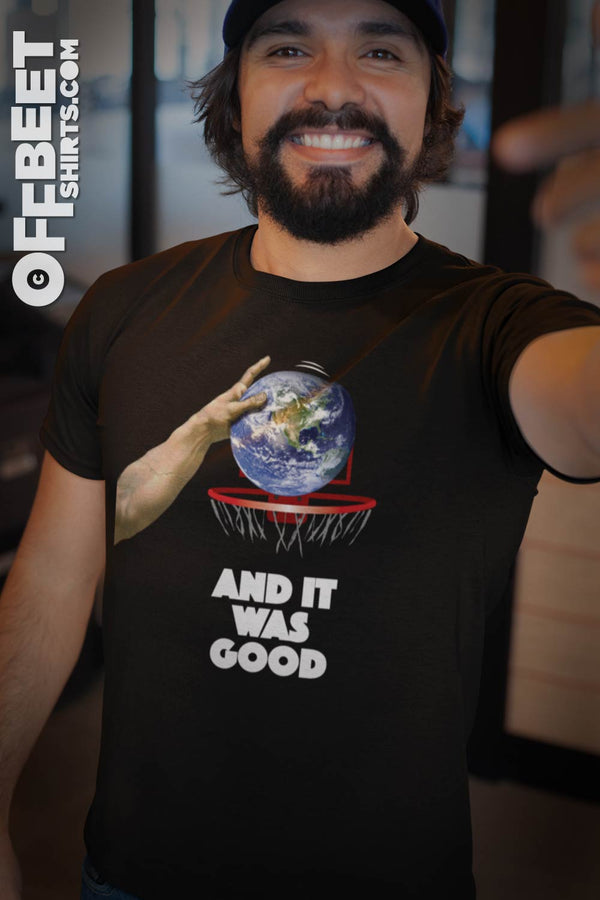 God discovers basketball No.2 Men’s Graphic T-shirt. A play on creation, God discovers basketball and it was good. Graphic of gods hand bouncing earth - type saying “and it was good” (Michelangelo’s hand of god). Mens black t-shirt  I  © 2019 Offbeet Shirts original design