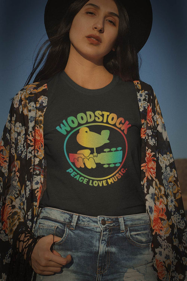 Woodstock rainbow graphic T-Shirt. Relive and celebrate the most iconic music festival in history. Woodstock surely was 3 days of peach and music.white graphic on black shirt dove settling on guitar neck with fingers over neck  I  Offbeet Shirts